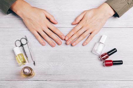 Female hands and manicure accessories on the table top view