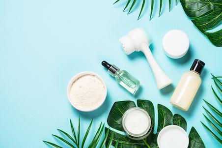 flat lay of acne skin care products including serums, creams and facial brush
