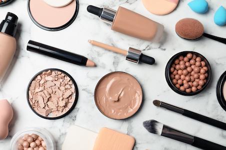 flat lay of face makeup products on marble background
