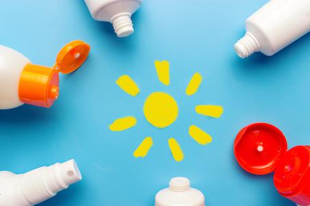 flat lay of sunscreen bottles on a blue background