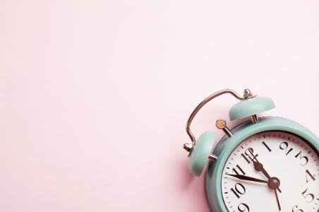 green alarm clock on a pink background