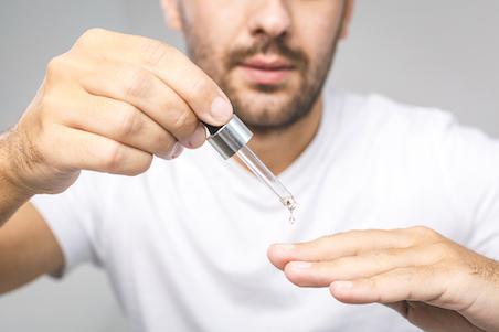 man applying cuticle oil to nails