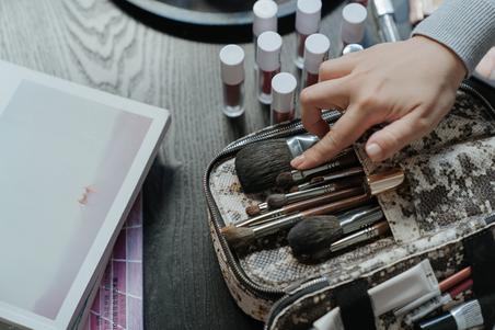 Person holding white and brown makeup brush set