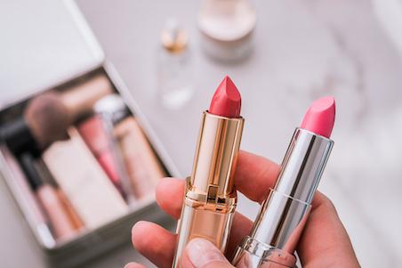 Photo of person holding two lipsticks