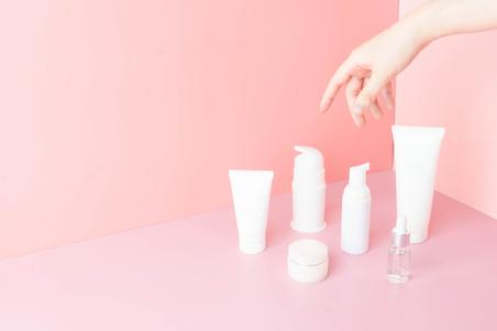 pink background with white cosmetic bottles