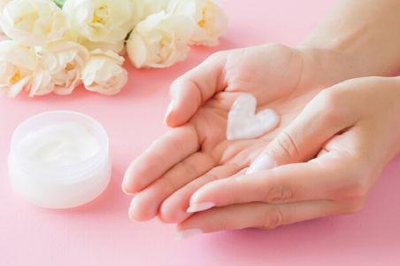 soft hands with hand cream in a heart shape