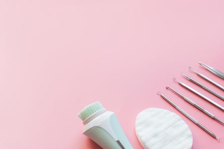 Tools for removing acne top view on pink background