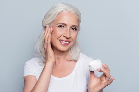 woman applying cream to face