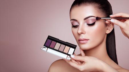 woman applying eyeshadow from eyeshadow palette