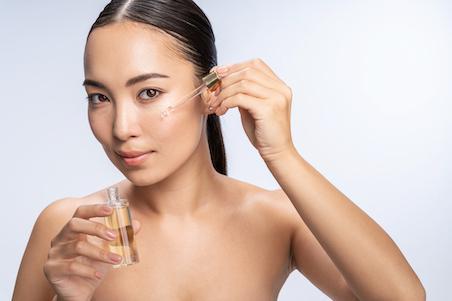 woman applying face serum