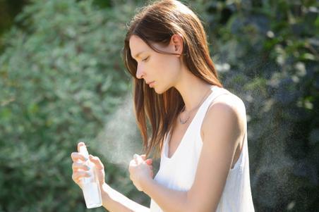 Woman applying heat protection to wet hair