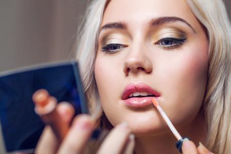 Woman applying lip gloss