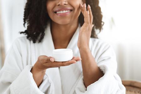 woman applying moisturiser to face