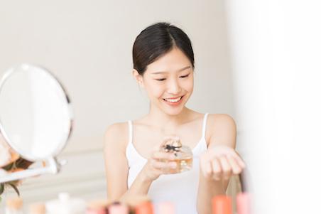 woman applying perfume to her wrists