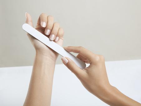 woman filing nails with nail file