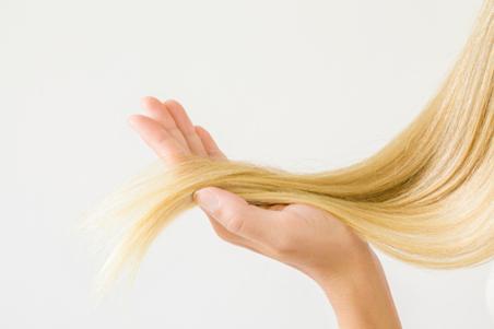 woman holding ends of blonde hair
