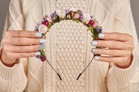 Woman holding floral headband hair accessory