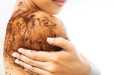 Woman is scrubbing body with coffee