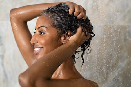 woman smiling washing hair in the shower