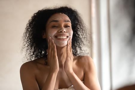 woman smiling with face wash on