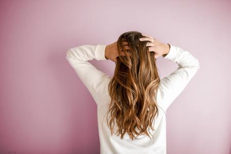 Woman with long hair on pink background