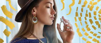 Woman smelling perfume with gold details