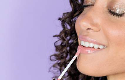 woman putting on lip product