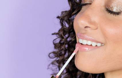 woman putting on lip makeup product