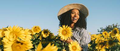 Women in field of sunflowers smiling