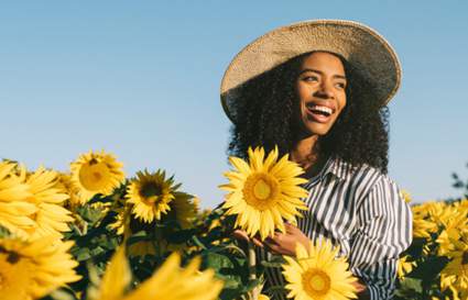 Women in field of sunflowers smiling