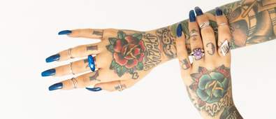 girl with tattooed hands and long blue nails