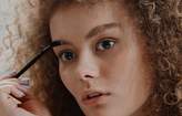 woman combing eyebrows