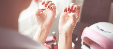 woman looking at her red nails