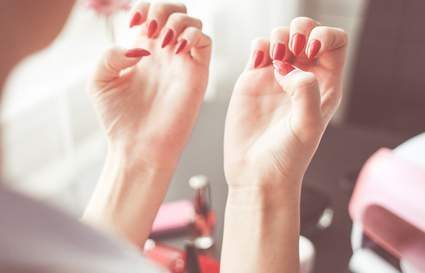 woman looking at her red nails