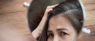 woman looking at grey hairs