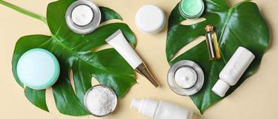 leaves next to beauty and skin care bottles