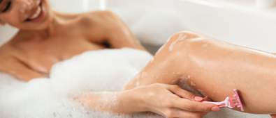 Woman shaving in the bath