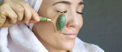 Women in a towel using a face massage roller