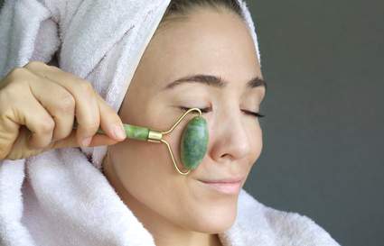 Women in a towel using a face massage roller