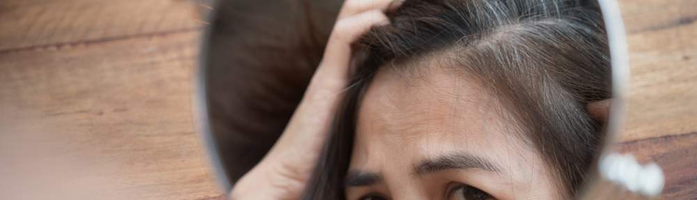 woman looking at grey hairs