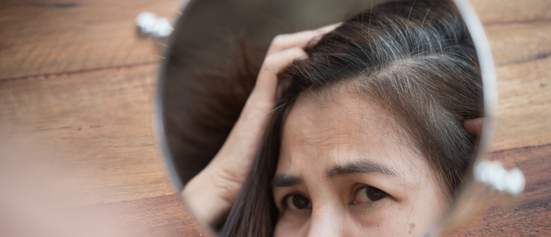 woman looking at grey hairs