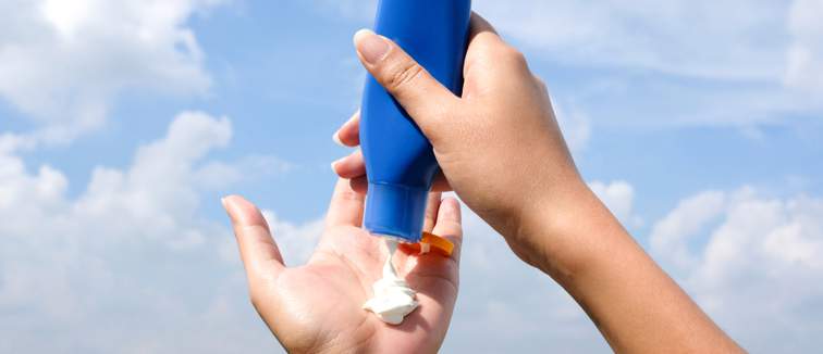 lady squeezing sun cream into hand
