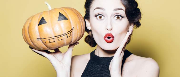 Woman holding a pumpkin wearing a retro red lipstick