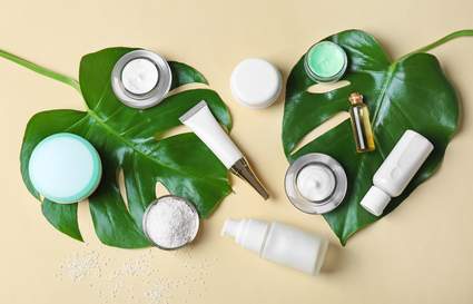 leaves next to beauty and skin care bottles