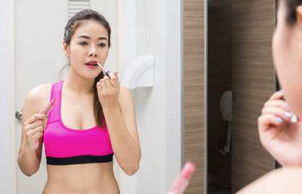 woman applying makeup in the gym