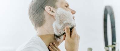 man shaving in mirror