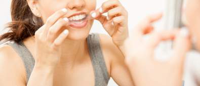 Lady using a teeth whitening strip