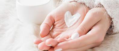 Cupped hands holding cream in heart shape