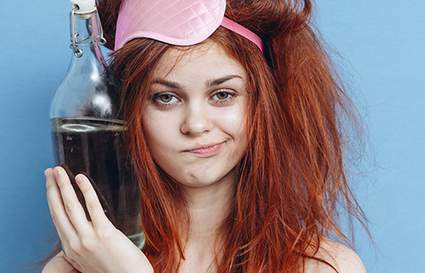 Woman with messy hair holding a bottle of water